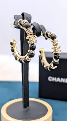 chanel boucles d'oreilles créoles en métal doré avec des perles en bois marron et perles en résine noir