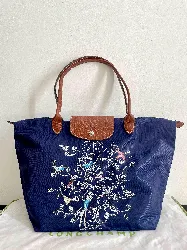 sac longchamps bleu avec dessin d 'oiseaux brodés porté épaule